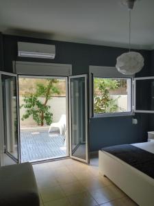Schlafzimmer mit einem Bett und einer Glasschiebetür in der Unterkunft Charilaou Trikoupi Flat in Athen