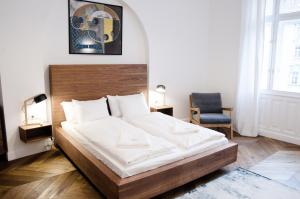 sypialnia z dużym łóżkiem z drewnianym zagłówkiem w obiekcie Luxury Apartment by Hi5 - Szervita Suite w Budapeszcie