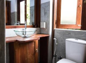 a bathroom with a bowl sink and a toilet at Villa Taprobane in Negombo