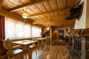 a dining room with a table and chairs and a fireplace at Rezydencja Bambi in Zakopane