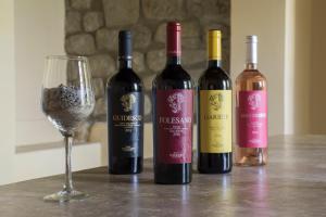 four bottles of wine and a wine glass on a table at Tenuta Folesano Wine Estate 13th century in Marzabotto +22 photos