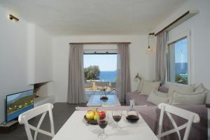 a living room with a table with wine glasses on it at SkiNAmmos Eco Villas in Marmari