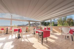 een restaurant met tafels en stoelen op een patio bij Hotel Flora in Noto