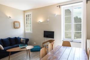 a living room with a blue couch and a table at La Maison des Vendangeurs 2 in Fleury