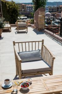 a bench sitting on top of a patio with a table at Hotel Off in Chania Town