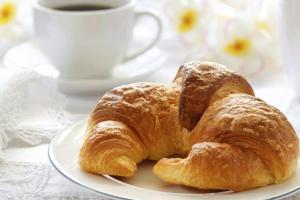 a plate with two croissants and a cup of coffee at Villa Milena in Agropoli