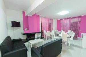a living room with pink walls and a table and chairs at Villa Milena in Agropoli