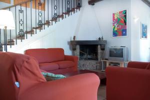 a living room with two red chairs and a fireplace at Villa in Punta Ala in Punta Ala