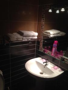 a bathroom with a sink and a mirror and towels at Hotel Rural El Cuco in Ribatajadilla