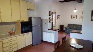 a kitchen with a refrigerator and a living room at Terre Regionali Toscane in Alberese