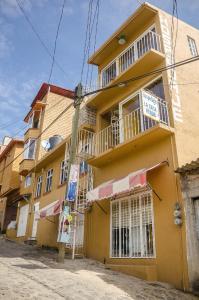 un edificio amarillo con balcón en una calle en Hospedaje Casa Verde, en Tepoztlán