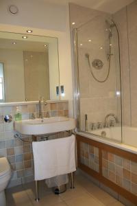 uma casa de banho com um lavatório, um chuveiro e um WC. em Bridge Street Apartments em Inverness