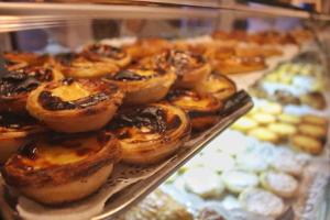 a bunch of pastries in a display case in a bakery at Burgos Guest House in Évora +31 photos