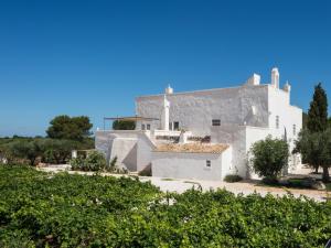 a white building with trees in front of it at Masseria Le Cerase in Conversano