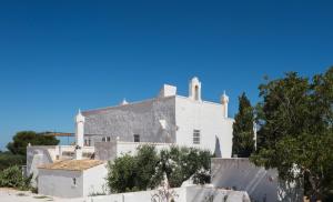 a white house with a fence in front of it at Masseria Le Cerase in Conversano