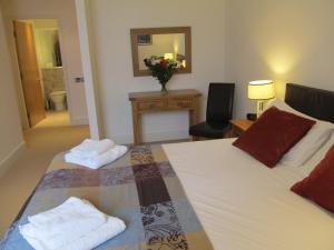 um quarto com 2 camas, uma secretária e uma cadeira em Bridge Street Apartments em Inverness