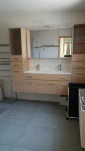 eine große Küche mit einem Waschbecken und einem Spiegel in der Unterkunft De Zandhoorn in De Panne
