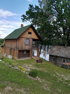 a large wooden barn with a green roof at Pie Ozola in Repši +19 photos