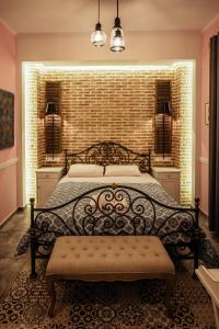a bedroom with a bed and a brick wall at Acronafplia Pension B&D in Nafplio