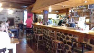 a bar in a restaurant with people sitting at tables at Chambres d'hôtes du Rebemol in Le Monastier sur Gazeille