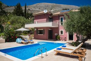 una villa con piscina frente a una casa en Villa Thalassini, en Agia Efimia
