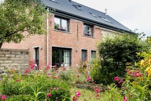 a brick house with flowers in front of it at B&B Destiny in Maldegem