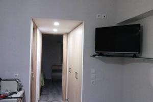Nianthy Apartments في فاليراكي: تلفزيون بشاشة مسطحة على جدار الغرفة