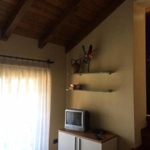 TV sentada en una mesa en una habitación con ventana en Villino Camparbino vista lago d orta, en Madonna del Sasso