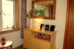 um quarto com uma cómoda e um espelho em Torcroft Lodges em Drumnadrochit