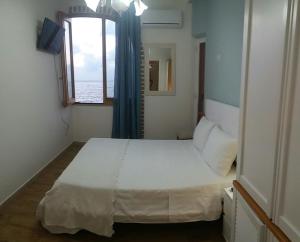 a bedroom with a large white bed and a window at Gabbiano Azzurro Flat Chianalea in Scilla