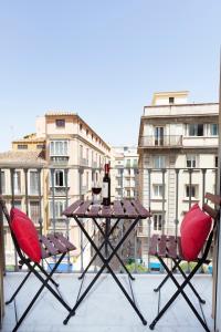 two chairs and a table on a balcony with buildings at iloftmalaga Puerta del Mar in Málaga