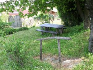 una mesa de picnic y un banco en el césped en Zalakaros Panoráma Apartmanok, en Zalakaros