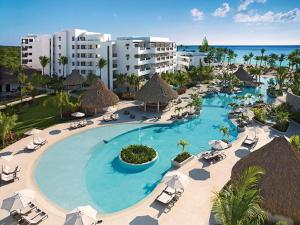 an aerial view of a resort pool with chairs and umbrellas at Secrets Cap Cana Resort & Spa - Adults Only in Punta Cana