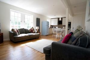 a living room with two couches and a kitchen at Mill Cottage in Lower Largo