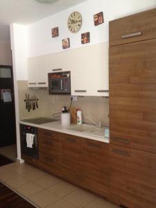 uma cozinha com um lavatório e um relógio na parede em Zamardiresort em Zamárdi