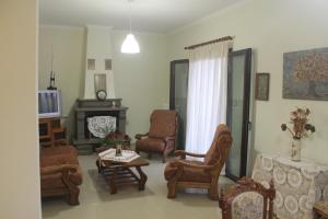 a living room with chairs and a table and a fireplace at Villa Bene in Preveza
