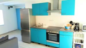 a kitchen with blue cabinets and a stainless steel refrigerator at Apartment Vrbenka in Vrbnik