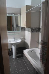 a bathroom with a sink and a tub and a mirror at Villa Bene in Preveza +6 photos
