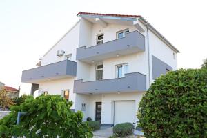 un edificio blanco con garaje en Guesthouse Villa DomeNico, en Lozovac