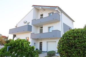 a white building with a garage at Guesthouse Villa DomeNico in Lozovac