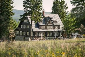 una gran casa negra con techo de gambrel en Prezidentská en Bedřichov