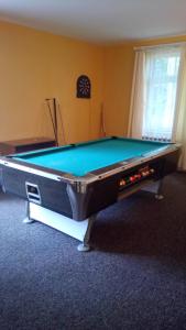 a pool table in the middle of a room at Hostel Dworek Osiecki KORAL in Osieki