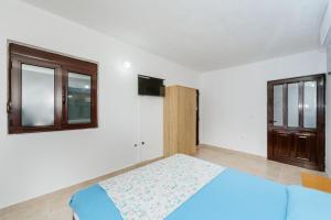 a bedroom with a blue bed and a window at MC Apartments in Ulcinj