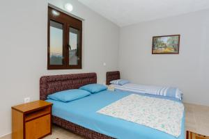 a bedroom with a blue bed and a window at MC Apartments in Ulcinj