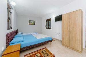 a bedroom with a bed and a wooden cabinet at MC Apartments in Ulcinj