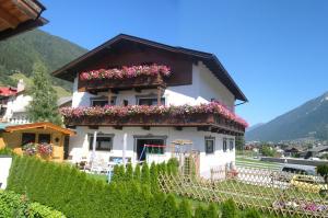 a white house with flower boxes on it at Pension Kristall in Neustift im Stubaital