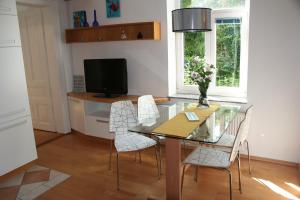 una sala da pranzo con tavolo in vetro e sedie di Dimora Apartments with free parking a Lubiana