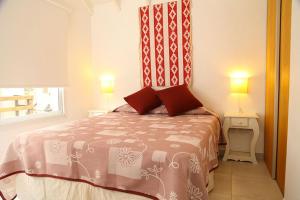 a bedroom with a bed with two pillows and a window at Complejo las Morochas in Valeria del Mar