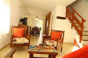 a living room with chairs and a table and a staircase at Complejo las Morochas in Valeria del Mar