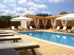 una piscina con tumbonas y sombrillas en Hotel Par Avion en Apriltsi